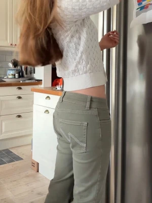 Gröna low waist  jeans med strassdetaljer - Snygga gröna bootcut jeans med dubbla knappar och strassdetaljer på bakfickorna. Jeansen har normalhög midja och klassisk femficksdesign. Perfekta för dig som vill ha en trendig och bekväm look. Og pris var 699kr!!!