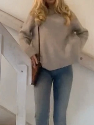 Beige stickad tröja - Snygg beige stickad tröja i underbar modell med rund hals och långa ärmar. Tröjan har en avslappnad passform och ribbade muddar vid ärmslut och nederkant. Perfekt att matcha med jeans för en trendig look.