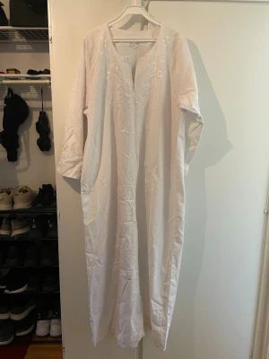 Vit Klänning/Abaya från Egypten - Vit klänning/abaya från Egypten. Funkar utmärkt till pilgrimsfärd till Mecka eller vid Ramadansamlingar. Aldrig använd. Tyget är 100 % bomull och är hårt, vilket gör den ogenomskinlig. 