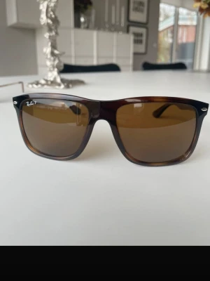 Ray ban boyfriend - Säljer ett par klassiska Ray-Ban Wayfarer solglasögon med brunmelerad plastbåge och bruna glas. Ikonisk modell med Ray-Ban-logga på både lins och skalmar. Snygg retrostil som passar till det mesta och ger en cool vibe.