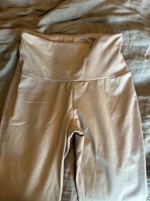 Beige höga midjeleggings - Snygga beige leggings med hög midja och stretchigt material. Perfekta för en avslappnad och trendig look. Mjuka och bekväma med slät yta och utan synliga loggor eller detaljer. ENDAST ANVÄNDA 1 GÅNG!