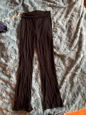 Svarta utsvängda leggings - Säljer ett par svarta leggings med utsvängda ben. De har hög midja och är gjorda i ett mjukt och stretchigt material, perfekt för en avslappnad och trendig look. Passar dig som gillar bekväma och stilrena byxor.