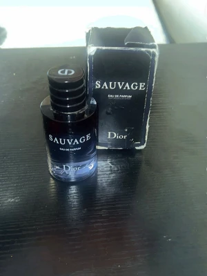 Dior Sauvage – Eau de Parfum (40 ml)ART 9 - Säljer en av marknadens mest hyllade herrdofter. Detta är Eau de Parfum-versionen, vilket ger en djupare och mer hållbar doft än den vanliga EdT:n. Flaskan har förvarats mörkt och svalt för att bevara doften perfekt. • Mängd: Ca 40 ml kvar. • Skick: Flaskan är som ny. Originalkartong medföljer (kartongen har spår av förvaring).
