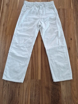 Vita raka jeans - Snygga vita jeans med rak passform och klassisk femficksdesign. Jeansen har normal midja och stängs med knapp och dragkedja. Perfekta för en clean och fräsch look. Materialet känns som bomull med lite stretch.