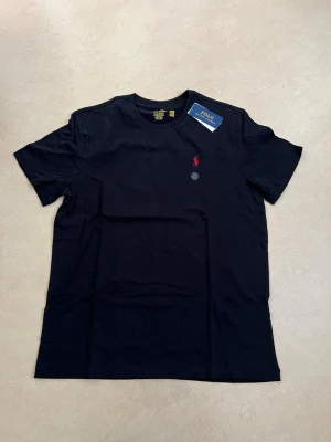 Ralph Lauren T-shirt svart storlek large - Ny Ralph Lauren t-shirt med klassisk passform. Perfekt basplagg till sommaren.  Oanvänd Väldigt populär modell Enkel att matcha  Skickas snabbt 📦 Rabatt vid köp av flera.