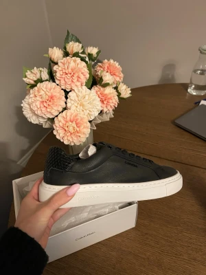 Svarta sneakers från Calvin Klein - Stilrena svarta sneakers från Calvin Klein med vit sula och snyggt mönstrad häl. Ej provade, nypriset ligger på 1595! Skickas i ordinarie kartong 🩷