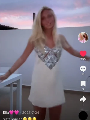 Zara klänning med paljetter - Snygg  klänning i creamvit med tunna axelband och glittrig silverpaljett på bröstet. Klänningen har en v-ringad design och är perfekt för dig som vill sticka ut. Materialet känns lätt och somrigt.