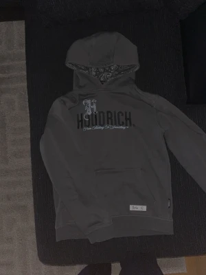 Grå hoodrich hoodie - Snygg grå hoodie från hoodrich. Mycket styilig och passar bra med mjukisbyxor och jeans.  Fina designs på den med också en fin design i luvan. 