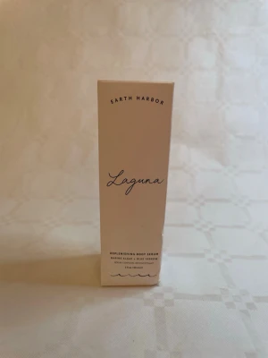 Earth Harbor Laguna Body Serum - Earth Harbor Laguna Replenishing Body Serum med marina alger och blå yarrow. Kommer i en stilren vit förpackning med svart text. Vegansk, växtbaserad och hållbar produkt som är framtagen i små batcher och är glutenfri.