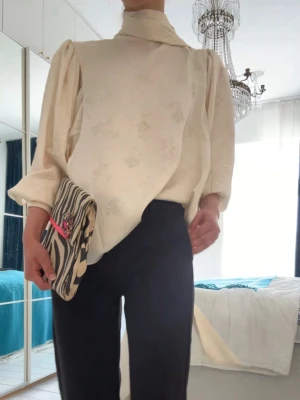 Krämvit blus med knyt och puffärm - Endast använd 1 gång! Krämvit/beige blus med knytband i ryggen. Storlek M men jag skulle säga att den funkar till S & M🌸🌸