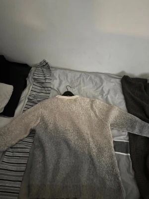 Corteiz C Star Gradient Mohair Knit SweaterGrey size m - Mysig stickad tröja i gråmelerad ton med stort vitt stjärnmönster på framsidan. Tröjan har rund halsringning och ribbstickade muddar vid ärmslut och nederkant. Perfekt för kalla dagar och enkel att matcha med jeans eller kjol.