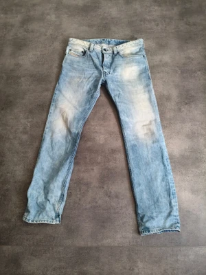 Ljusblå raka jeans - Säljer ett par ljusblå jeans med raka ben och snygga slitningar. Jeansen har klassisk femficksmodell och är gjorda i denim. Perfekta för dig som gillar en avslappnad och trendig look.