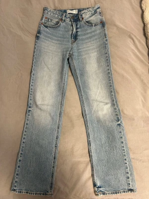 Ljusblå raka jeans stradivarius - Säljer ett par ljusblå jeans från stradivarius i modellen ”D98” med raka ben och medelhög midja. Jeansen har en snygg tvättad look och råa kanter längst ner på benen för en trendig vibe. De är endast använda ca 5 gånger.