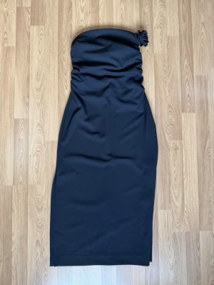  Svart maxi klänning från H&M  -  Svart maxi klänning från H&M med två slits på varsin sida och dragkedja på vänster sida. Blomman går att spänna av och på.