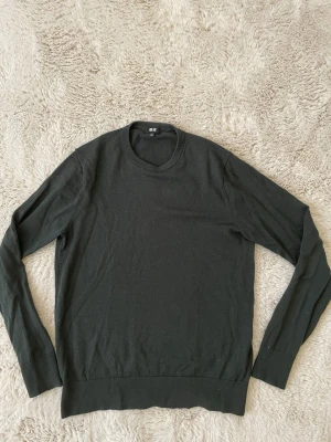 Mörkgrön tröja från Uniqlo - Säljer denna mörkgröna tröjan från uniqlo! Tröjan är lite tunnare vilket passar perfekt nu till de varmare dagarna. Tröjan har ett litet hål på vänster arm som går att laga men som annars inte riktigt märks. Kontakta vid funderingar!
