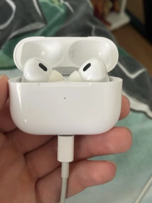 Apple AirPods Pro med laddningsetui - Säljer ett par vita Apple AirPods Pro med trådlöst laddningsetui. Hörlurarna har en stilren och kompakt design med silikonproppar för extra komfort. Perfekta för musik, samtal och brusreducering. Laddas enkelt via Lightning-kabel.