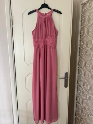 Rosa långklänning med spetsdetalj - Säljer en superfin rosa långklänning med spets i midjan och ärmlös design. Jag har använd klänningen en gång, på 9:an bal 2022. En bekväm och snygg klänning som passar till fler olika tillfällen