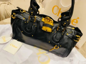 Svart handväska från Chloé med gulddetaljer - Har haft den i 3 år . Kommer med kvitto. Den är i jätte bra skick. Kvitto finns också 