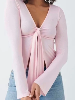 Gina tricot tie front top  - Trendig ljusrosa topp med lång ärm och djup v-ringning. Toppen har en snygg knyt-detalj framtill. 