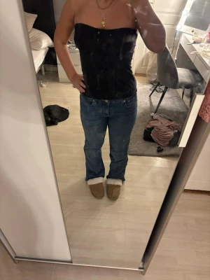 Blå raka jeans med normal midja - Säljer ett par klassiska blå jeans med rak passform och normal midja. Jeansen har fem fickor och stängs med dragkedja och knapp. Materialet är denim i bomull och färgen är en tidlös mellanblå nyans. Perfekta till sneakers eller boots.