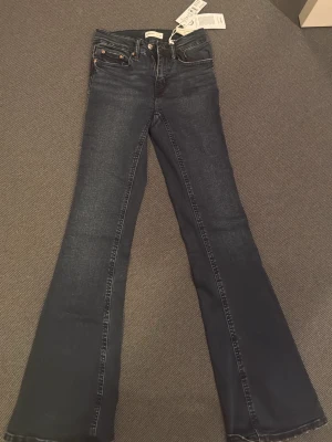 Mörkblå bootcut jeans från Perfect Jeans - Snygga mörkblå bootcut jeans från Perfect Jeans med klassisk femficksdesign och silverfärgade detaljer. Jeansen har en lätt utsvängd passform nedtill och är tillverkade i ett mjukt denimtyg som sitter bekvämt hela dagen.