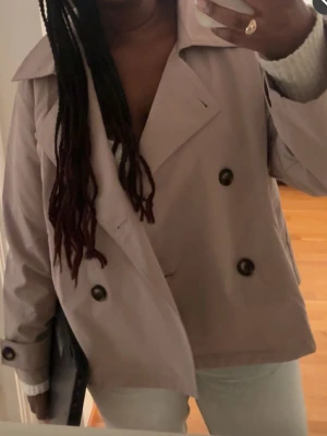 Ljusbeige trenchcoat med dubbelknäppning - Stilren ljusbeige trenchcoat med klassisk dubbelknäppning och bred krage💕