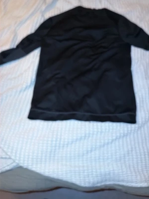 Svart långärmad tröja från Adidas - Säljer en svart långärmad sporttröja från Adidas med diskret logga på bröstet. Tillverkad i ett lätt och funktionellt material som passar perfekt till träning eller uppvärmning. Tröjan har en enkel och stilren design.