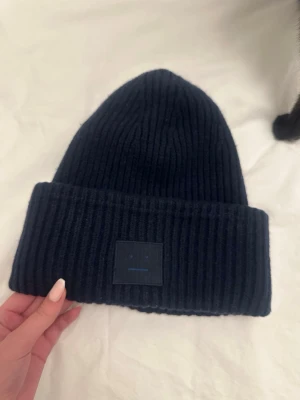 Mörkblå mössa Acne Studios - Säljer denna acne mössa då den inte har används. Köpte mössan ny. Bara använt ett fåtal gånger, har inte tvättat den så den är bra i kvalitet. Sitter bekvämt😊😊