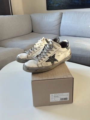 Golden Goose vita sneakers med svart stjärna - Ett par riktigt unika golden goose med sula i bra skick!! Köpa  i utlandet och säljer då jag är sugen på något nytt. Skriv för frågor!!