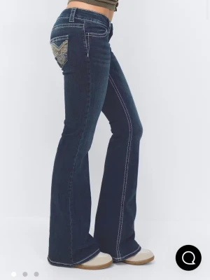 Mörkblåa bootcut jeans från Gina Tricot - Snygga mörkblåa bootcut jeans från Gina Tricot med vita sömmar. Fina fickor och låg midjade. Lappen är väldigt sliten så man ser inte storleken men den är i 152🫶