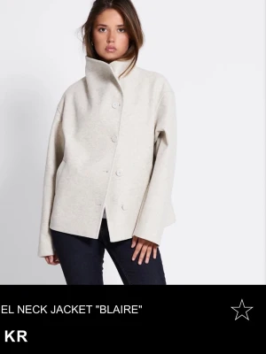 Beige kappa med hög krage - Stilren beige jacka ”Blaire” fråm Lager 157 med hög krage och knäppning framtill. Jackan har en rak, loose passform. Perfekt för dig som gillar minimalistisk och modern stil. Den är helt oanvänd , i storlek XS. Säljer för att det tyvärr inte satt bra på mig. 