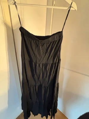 Svart långkjol - Svart långkjol, kjolen har flera volanglager och ett lätt, mjukt tyg som ger ett flowy intryck. Perfekt för sommarens varma dagar eller när du vill ha en enkel men snygg look.