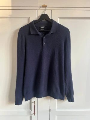 Marinblå knapptröja från Galerie Lafayette - Säljer denna stilrena kashmir tröjan från Galeries Lafayette i st M!🔥😎 Tröjan är utav 100% Kashmir och köpt på Galeries Lafayette i Paris! Tröjan har klassisk design med knappar och är i utmärkt skick. Tröjans tjocklek och färg passar perfekt för våren och sena sommarkvällar med riktigt skönt material och design! Skriv gärna vid frågor eller t.ex. mått!