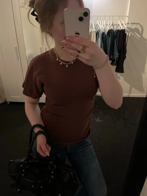 Vinröd  tröja - En enkel vinröd t-shirt med rund hals och korta ärmar. Modellen är figurnära och passar perfekt till jeans eller kjol. T-shirten är tillverkad i mjuk bomull och har en klassisk, stilren look utan tryck eller logga. Inga defekter.