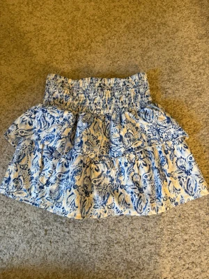 Blåvit volangkjol från Gina Tricot - Fin kjol för sommaren, passar som kjol och topp. Jätte skönt matrial med volang.