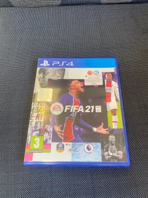 FIFA 21 till PS4 - FIFA 21 till PlayStation 4 i blå plastfodral. Omslaget har färgstarka bilder på fotbollsspelare och spelets logga. Spelet är ett fotbollsspel där du kan spela med olika lag och ligor. Skivan och fodralet har officiella märkningar och åldersgräns 3 år.