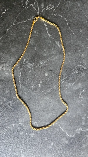 Cordell halsband 55 - Snyggt guldpläterat halsband med tvinnad kedja och karbinlås. Halsbandet har en klassisk och stilren design som passar till många olika looks. Perfekt accessoar för dig som gillar enkel men elegant stil.