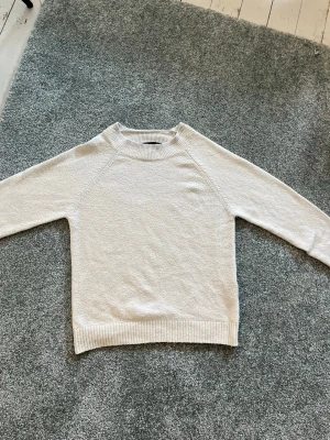 Fin vit stickad tröja med rund hals från Vera Moda - En enkel och stilren vit stickad tröja med rund hals och långa ärmar. Tröjan ger en clean look som passar till de flesta outfits. 