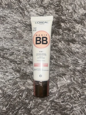 L'Oréal Magic BB Cream Light - Magic BB Cream från L'Oréal Paris i nyansen Light. Tuben är vit med rosa och svart text samt har ett roséguldigt lock. Produkten är en 5-i-1 foundation med vitamin C-komplex som jämnar ut hudtonen och ger en naturlig finish.