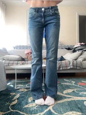 Blå bootcut jeans från Gina Tricot - Snygga blå bootcut jeans från Gina Tricot med fisk fickor. Jeansen har justerbar midja, de är i super bra skick och i storlek 170💘😊 längst ner på benen har jeansen förtärds lite men de ör forfarande lika fina🫶