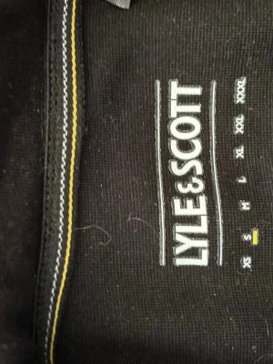 Svart hoodie från Lyle & Scott - Säljer en svart hoodie från Lyle & Scott, den är inte använd bara lite hårig från katt men går bort i tvättmaskinen