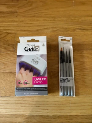 Depend GeliQ UV/LED Lampa & Penselkit - Säljer ett Depend GeliQ UV/LED-lampa för gelnaglar samt ett Nail Art Brush Kit med fyra olika penslar. Lampan är vit och kompakt, perfekt för hemmabruk. Penslarna har gråa skaft och olika former för detaljerad nagelkonst. En av borstarna är använda en gång men rengjord och lampan är endast använd 2 gånger men är som ny