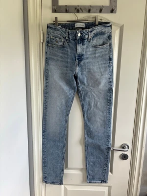Ljusblå raka jeans med hög midja - Snygga ljusblå jeans med raka ben och hög midja. Klassisk femficksmodell med dragkedja och knapp framtill. Jeansen har en stilren tvätt och är gjorda i denim med en lätt stretch. Perfekta till en avslappnad look.