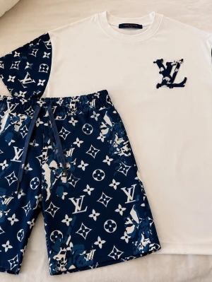 Louis Vuitton-inspirerat set (T-shirt + shorts) – Storlek S - Säljer ett riktigt snyggt set med matchande t-shirt och shorts, båda i storlek S. Perfekt för sommaren eller för en stilren casual look.  Materialet på både t-shirten och shortsen är av väldigt hög kvalitet – tyget är tjockt, tungt och känns exklusivt, inte tunt eller billigt som många andra set. Båda plaggen har en stadig och lyxig känsla med bra passform.    Den har småa svarta prickar på Tishirt men syns verkligen inte och det är jättt jättt småa man märker Ingeting!!!   Alltid ärlig Hoss oss
