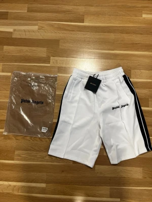 Palm Angels Shorts - Säljer ett par helt nya Palm Angels shorts. Shortsen är oanvända och kommer med tags samt påse. Stilren och exklusiv design som passar perfekt till sommaren. Nypris är betydligt högre, detta är ett riktigt bra pris för ett par i nyskick. Hör av dig vid intresse eller om du vill ha fler bilder.