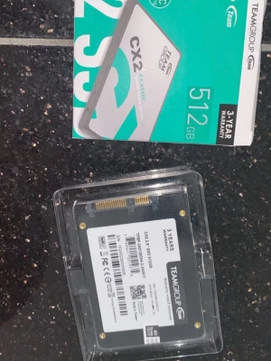 TEAMGROUP CX2 512GB SSD - Säljer en TEAMGROUP CX2 Classic SSD med 512GB lagringsutrymme. Den har en stilren design i silver och turkos, och ansluts via SATA 6Gb/s. Perfekt för att snabba upp din dator eller laptop med snabbare lagring.