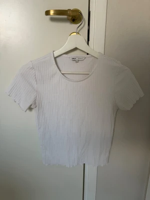 Vit ribbad topp från ONLY - Säljer en vit ribbad topp från ONLY i storlek S.  Perfekt till sommaren att matcha med jeans eller kjol🤍