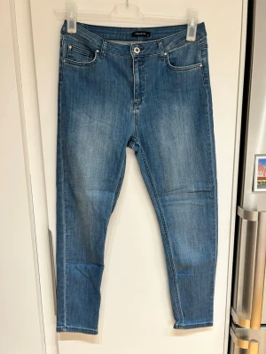Blå jeans från Trendyol - Snygga blå jeans från Trendyol med klassisk femficksdesign och normal passform. Jeansen har en ljus tvätt och är tillverkade i bomull med en knapp och dragkedja framtill. Perfekta för en avslappnad och stilren look.