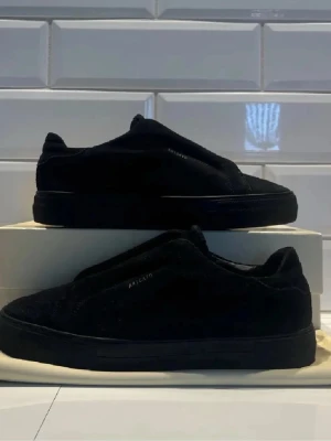 Svarta sneakers från Axel Arigato hade kunnat tänka mig att byta  - Stilrena svarta sneakers från Axel Arigato i mocka med minimalistisk design och diskret logga på sidan. Skorna har en låg silhuett och svart sula som ger en clean look. Perfekta för dig som gillar enkel och modern stil.