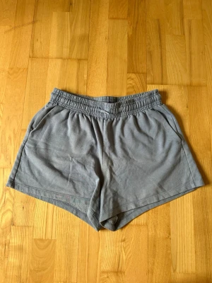 Ljusblå bomullsshorts från 157 - Mysiga ljusblå shorts från 157 med elastisk midja och avslappnad passform. Tillverkade i mjuk bomull, perfekta för varma dagar eller chill hemma. Klassisk design utan mönster och med fickor på sidorna. Har använts väl, men är i fint helt skick. Kanske något urtvättade. 